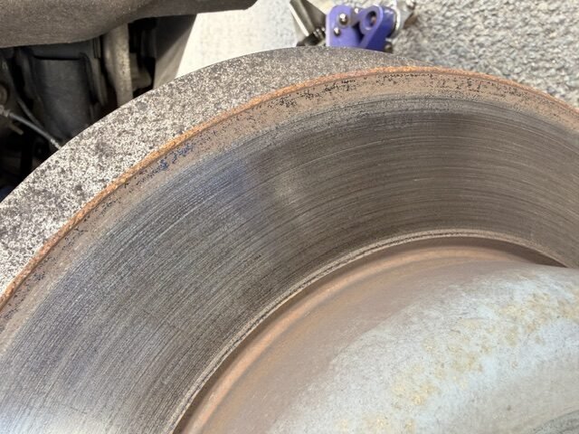 Close-up of brake rotor edge showing rust and wear grooves